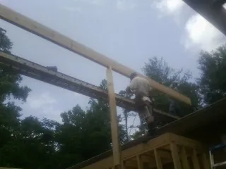 Carpenter setting a ridge beam over a new addition frame — Ice Dam Removal by Roofing Brothers in Sligo
